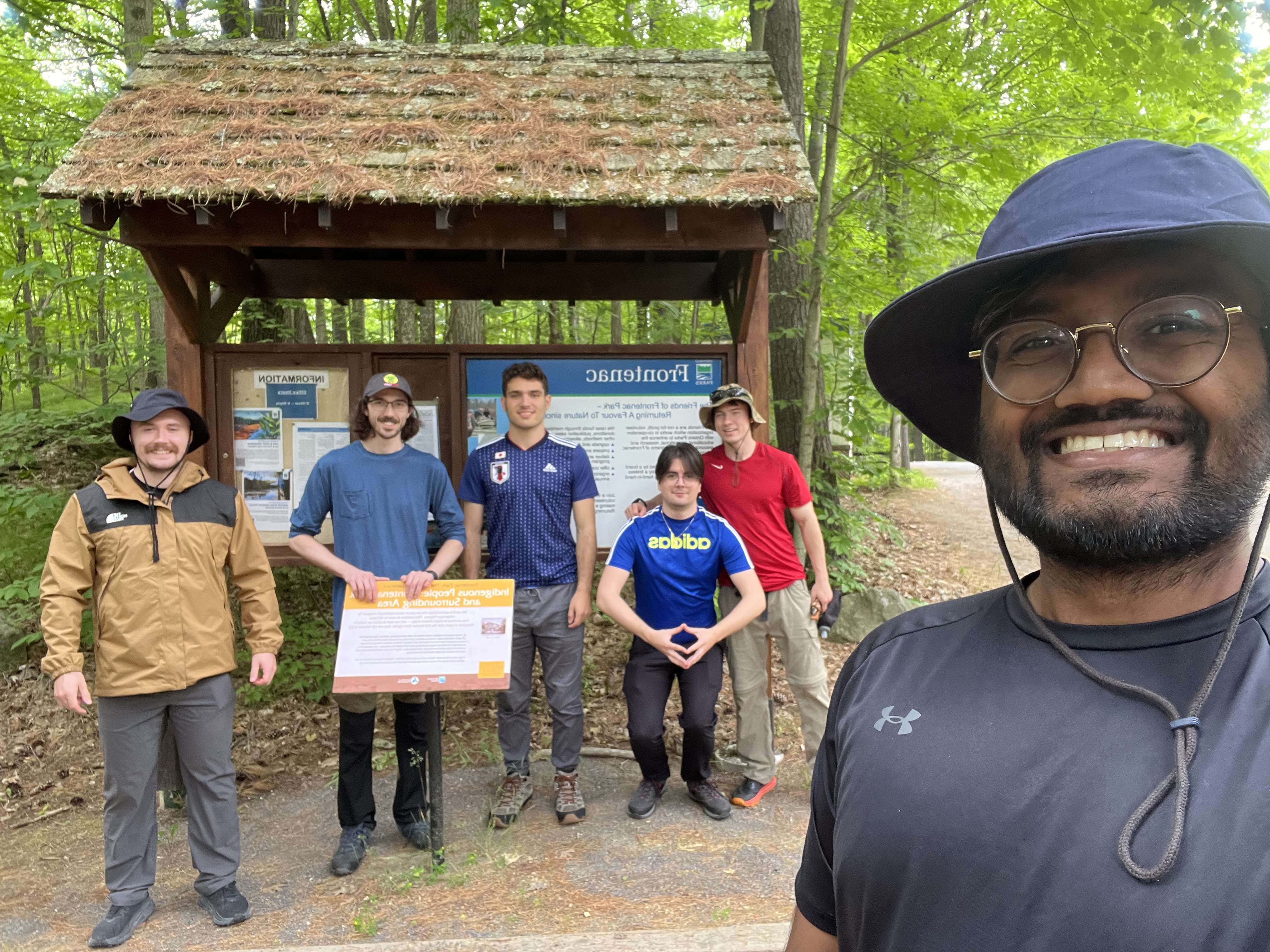 6 guys standing infront of a sign